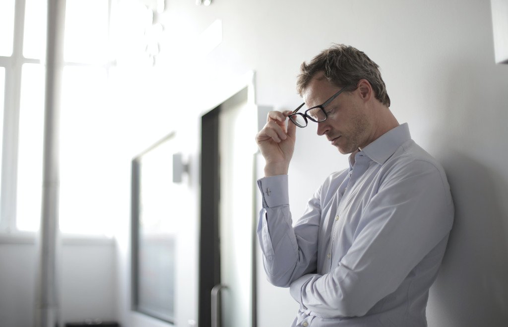 handle redundancies well (man taking off glasses by Andrea Piacquadio)